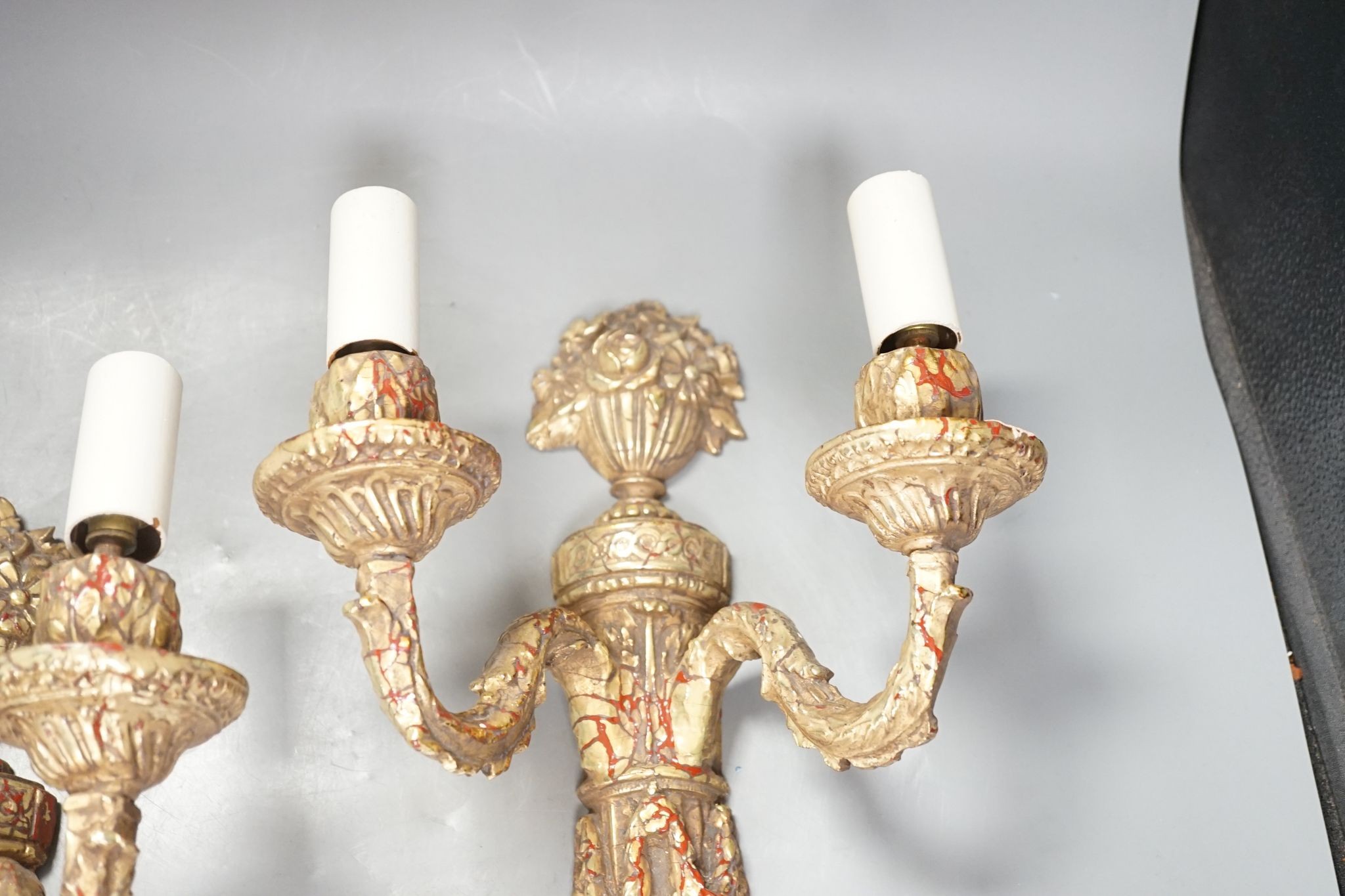 A pair of neo-classical style gilt composition twin-light wall sconces, 38cm